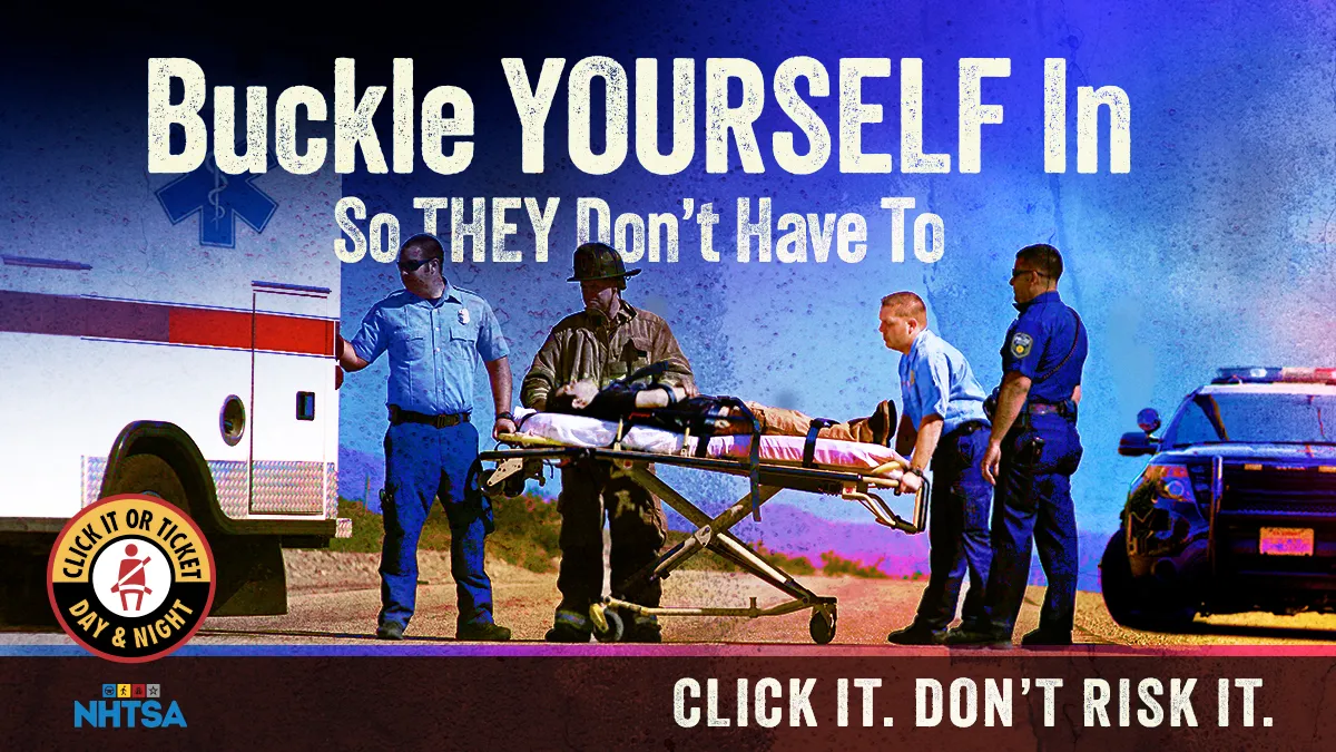 Buckle Yourself In So The Medics Don't Have To. CLICK IT. DON'T RISK IT. ~ Shows emergency personnel loading a patient buckled to a gurney into an ambulance.